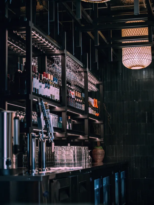 Bar shelves stocked with liquor bottles and glassware at Kanpai Ramen, a Ramen Restaurant in New Port Richey