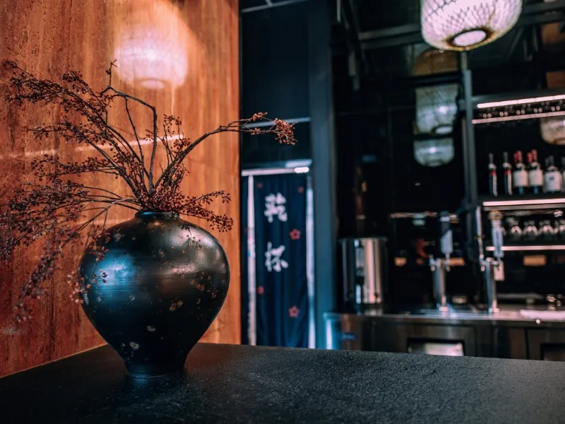 Decorative black vase with dried branches at Kanpai Ramen, a Ramen Restaurant in New Port Richey