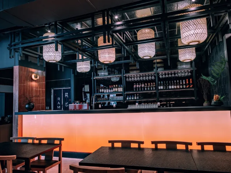 Modern dining area with bar and warm lighting at Kanpai Ramen, a Ramen Restaurant in New Port Richey