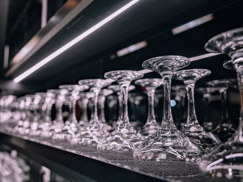 Polished wine glasses neatly arranged on a rack at Kanpai Ramen, a Ramen Restaurant in New Port Richey
