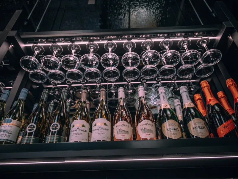 Wine and champagne bottles with hanging glasses at Kanpai Ramen, a Ramen Restaurant in New Port Richey